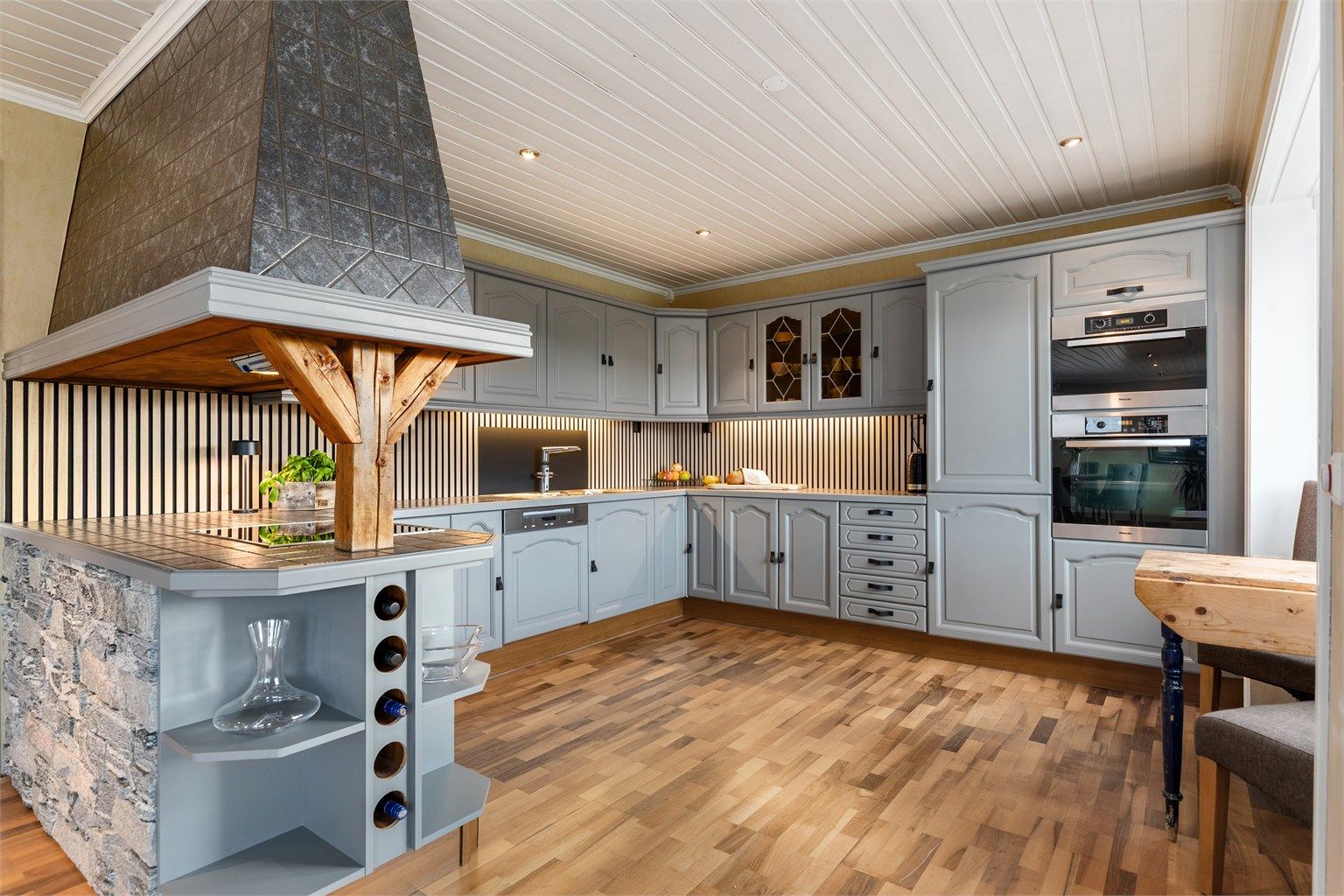 Pent velutstyrt kjøkken med eikespiller mellom over og underskap 