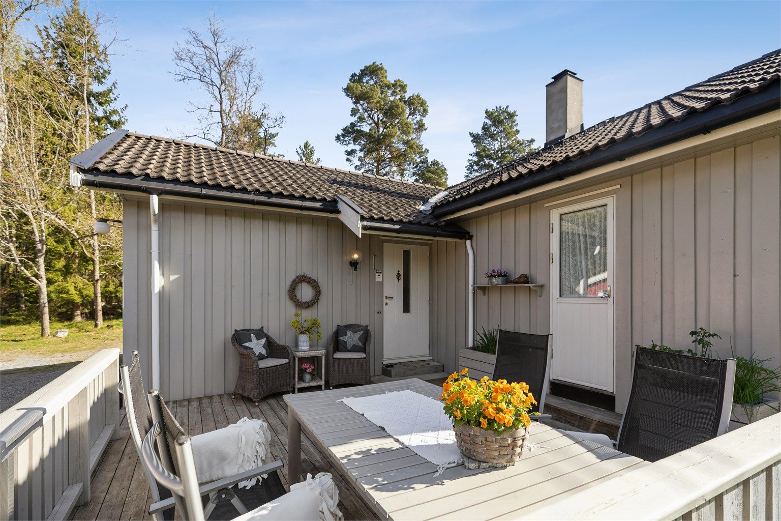 Innbydende terrasse i tilknytning til inngangspartiet, perfekt for en hyggelig velkomst og sitteplass.