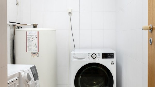 Separat vaskerom i kjeller med opplegg for vaskemaskin og en 200-liters varmtvannsbereder.