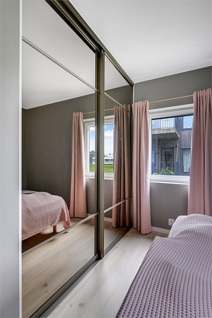 Skyvedørsgarderobe med speilfronter gir rikelig med lagringsplass og en god romfølelse.