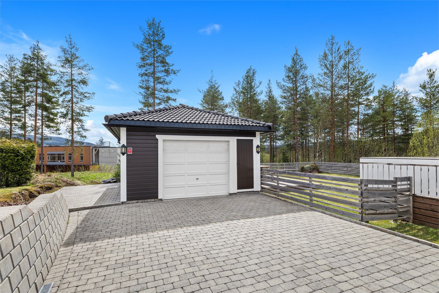 Eiet tomt opparbeidet med belegningsstein, terrasse på terreng, biloppstillingsplass, plenarealer, diverse beplantninger. Frittstående garasje.