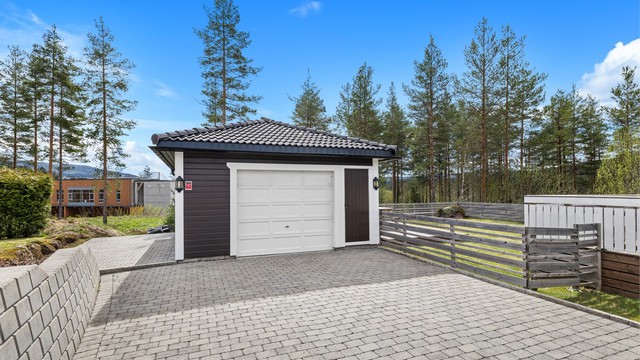Eiet tomt opparbeidet med belegningsstein, terrasse på terreng, biloppstillingsplass, plenarealer, diverse beplantninger. Frittstående garasje.