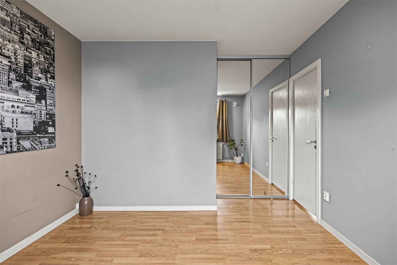 Soverommet har integrert skyvedørsgarderobe med speilfronter.
