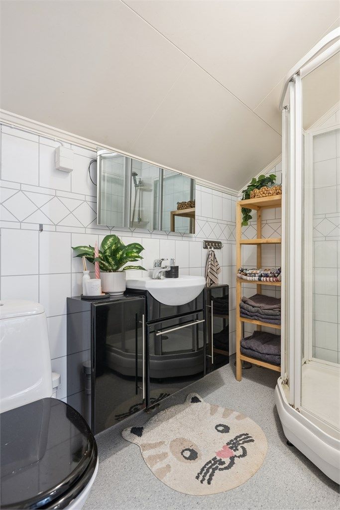 Badet inneholder servantinnredning, dusjkabinett og toalett.