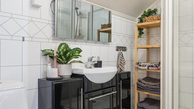 Badet inneholder servantinnredning, dusjkabinett og toalett.