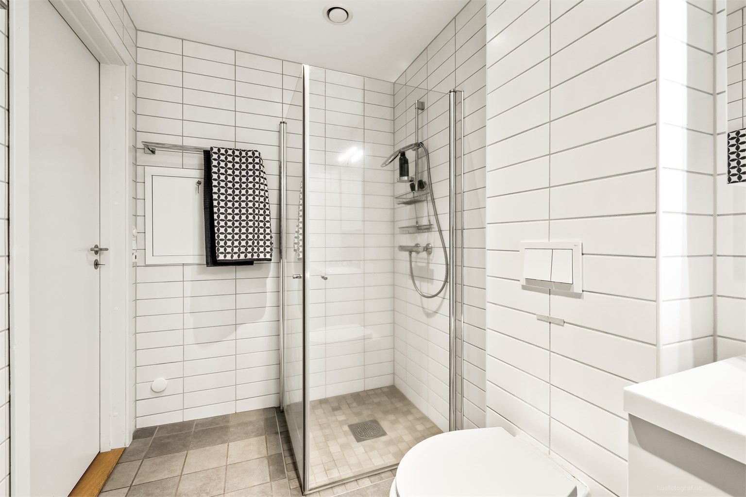 Her er det et praktisk dusjhjørne med innfellbare dører og opplegg for vaskemaskin.