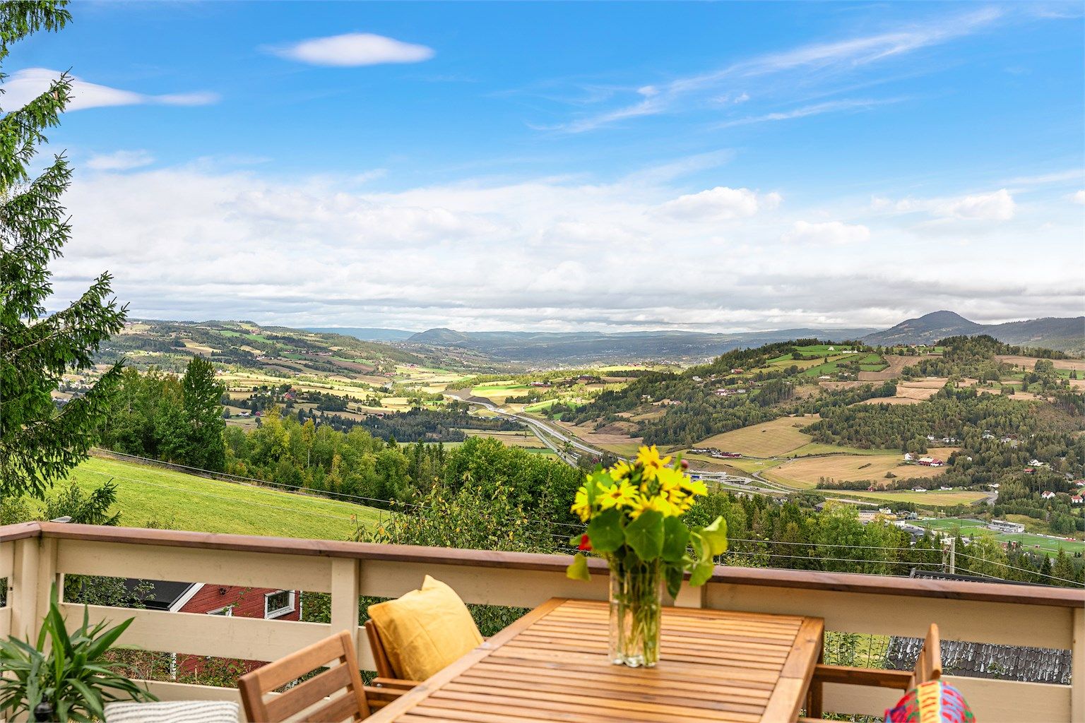 Fantastisk panoramautsikt over skog, fjell og åkerlandskap.