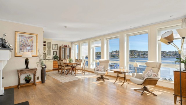 Koselig og fin stue med belysning over hvert vindu som gir en stemningsfull atmosfære og fremhever det vakre panoramaet.