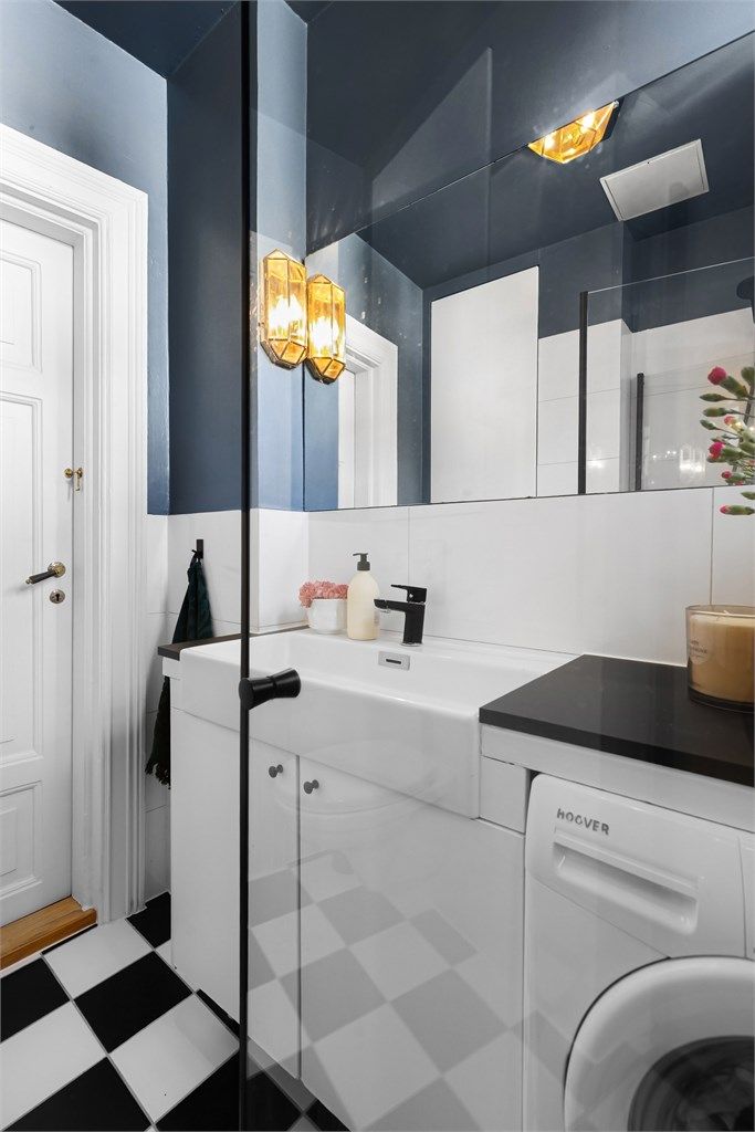 Badet er utstyrt med vegghengt toalett og dusjhjørne med innfellbare glassdører.