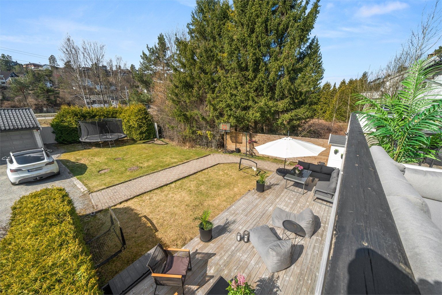 Fra balkongen har man oversikt over hagen og markterrassen. God plass til lek og moro. Uteområdene er definert som fellesareal i seksjoneringen men benyttes i praksis av denne seksjonen.