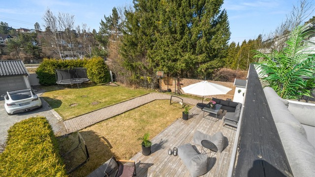 Fra balkongen har man oversikt over hagen og markterrassen. God plass til lek og moro. Uteområdene er definert som fellesareal i seksjoneringen men benyttes i praksis av denne seksjonen.