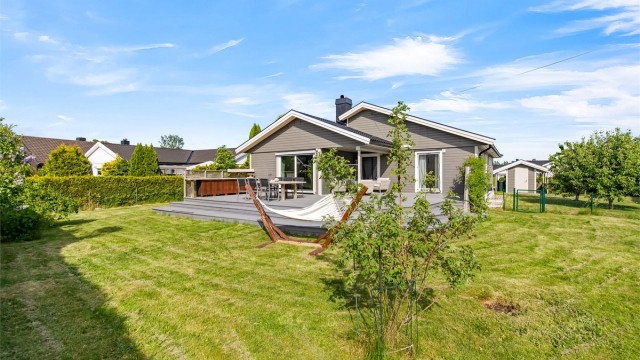 Boligen ligger fint plassert på tomten som gir et romslig plenområde