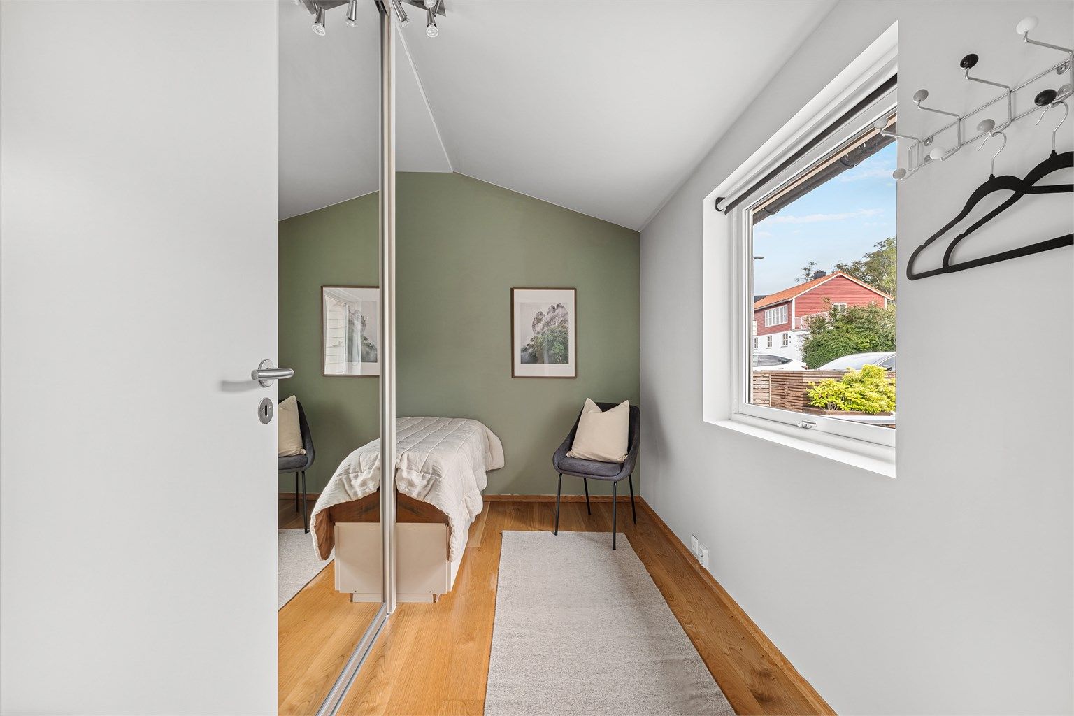 Soverom I med plass til stor seng og medfølgende skyvedørsgarderobe med speilfronter.
