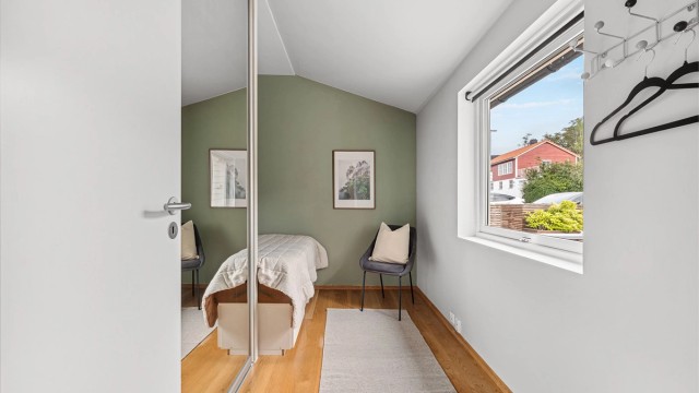 Soverom I med plass til stor seng og medfølgende skyvedørsgarderobe med speilfronter.