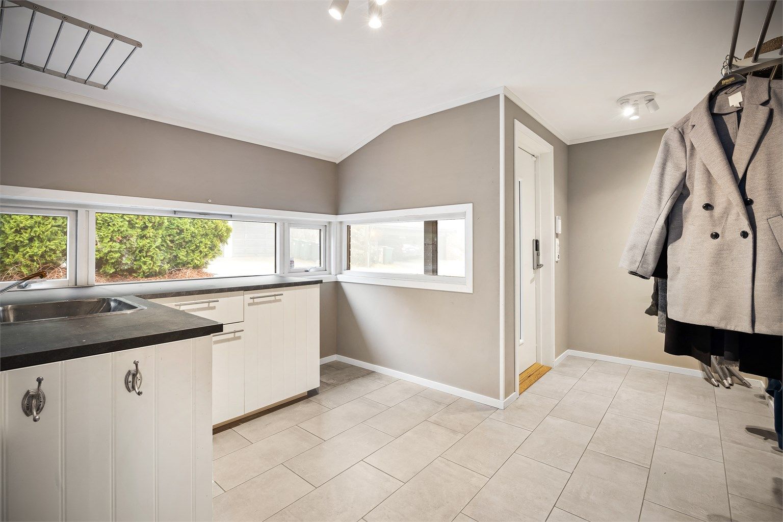 Den ene entréen har satt inn en profilert kjøkkeninnredning med oppvaskkum