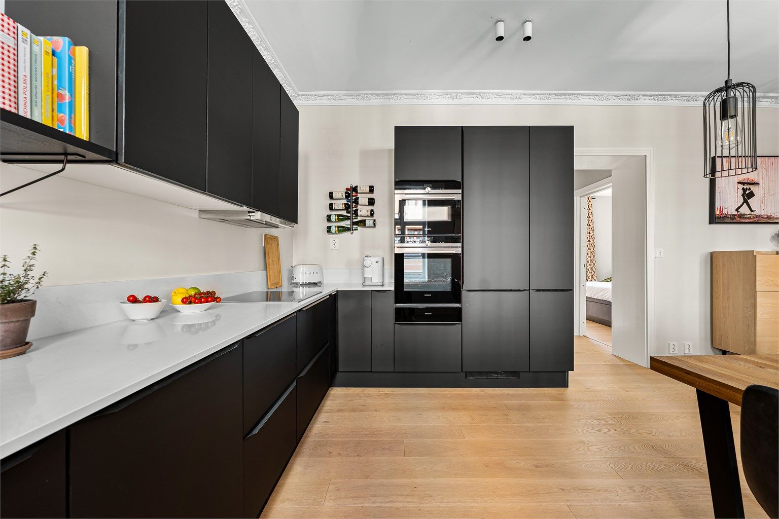 Kjøkkenet er fra HTH og ble pusset opp i 2021 og har moderne løsninger med slette skapfronter, benkeplate i kvarts og integrerte hvitevarer, inkludert oppvaskmaskin.