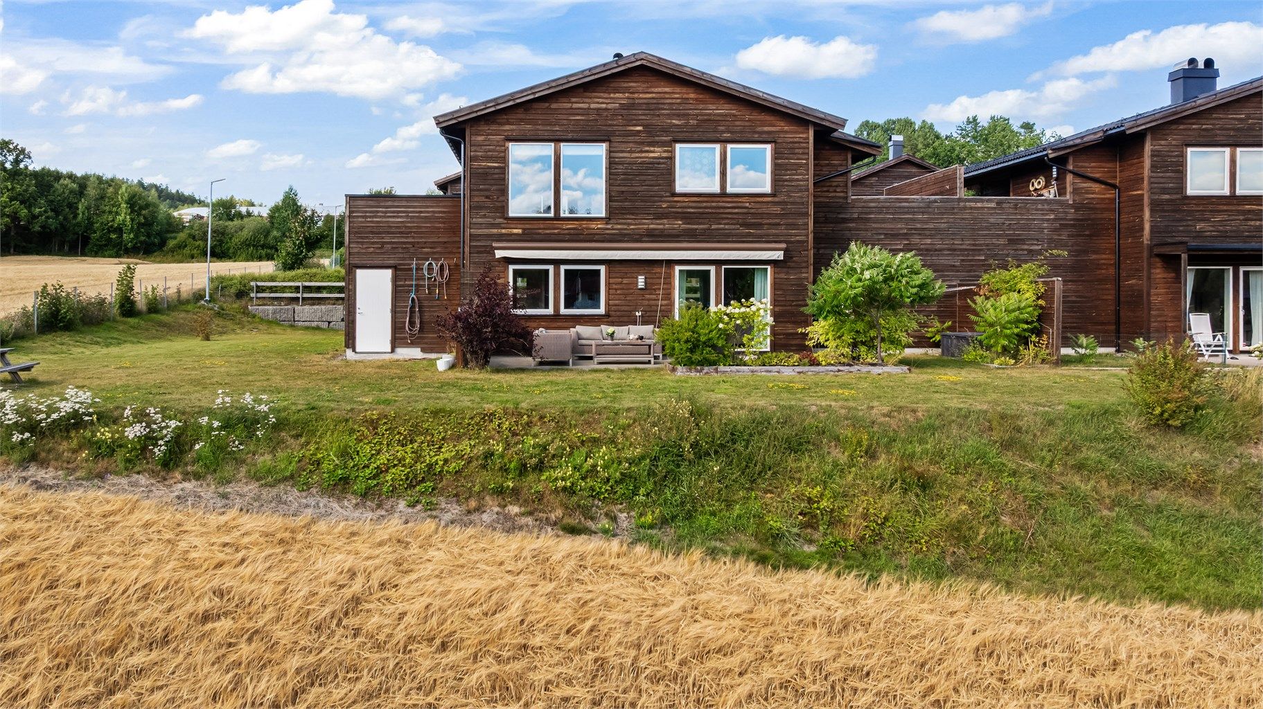 Boligen har en usjenert beliggenhet med hage og terrasse mot et landbruksområde.
