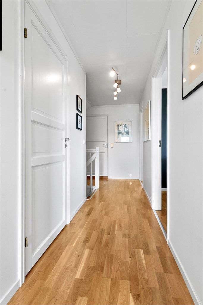 Gang i loftsetasjen med malte fyllingsdører som fører inn til soverommene og badet