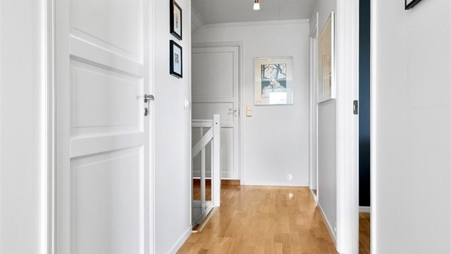 Gang i loftsetasjen med malte fyllingsdører som fører inn til soverommene og badet