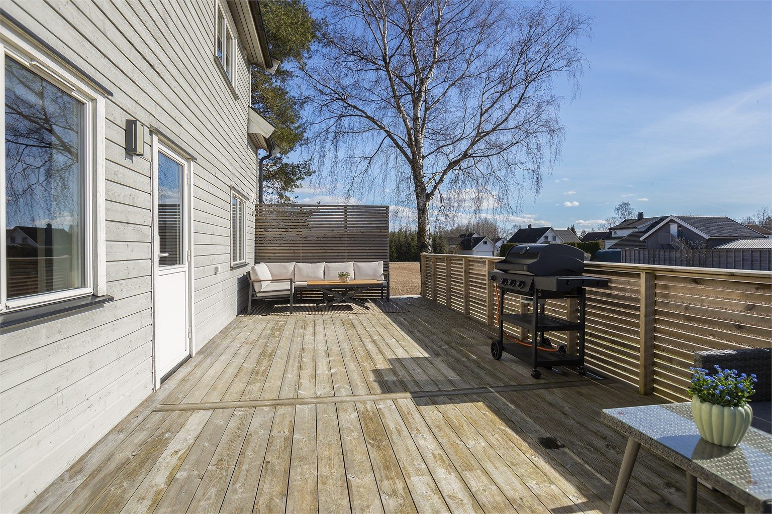 Terrassen på 39 m² er bygget i trekonstruksjon og har trapp ned til hagen.
