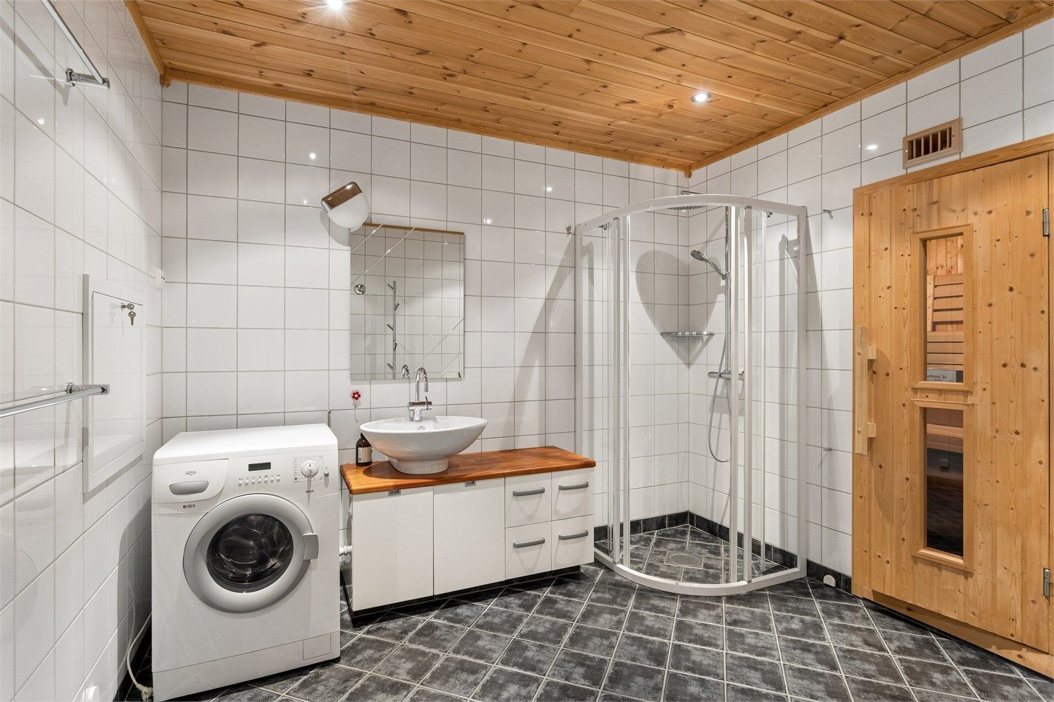 Baderommet har servantinnredning med ovenpåliggende servant og god benkeplass.