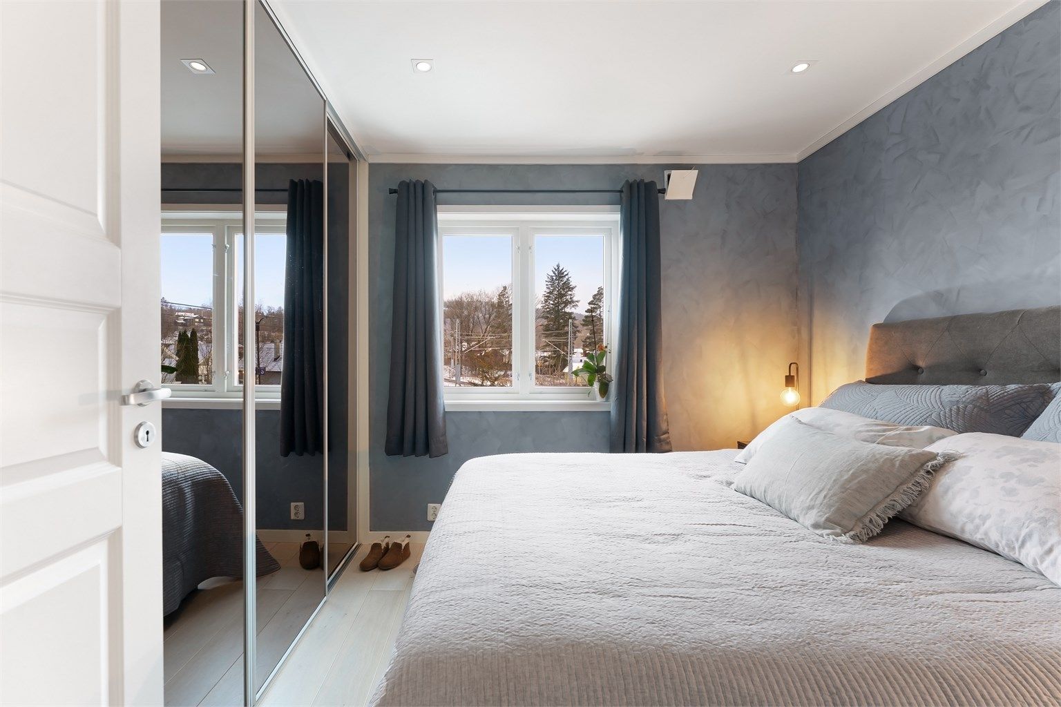En stor skyvedørsgarderobe med speilfronter gir rikelig med oppbevaringsplass.