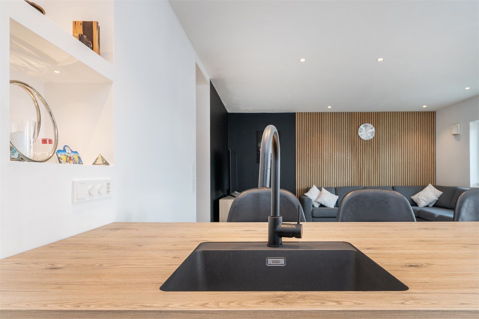 Detaljer som den sorte, underlimte vasken og stilrene blandebatteriet understreker den gjennomførte stilen.