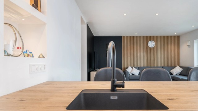 Detaljer som den sorte, underlimte vasken og stilrene blandebatteriet understreker den gjennomførte stilen.