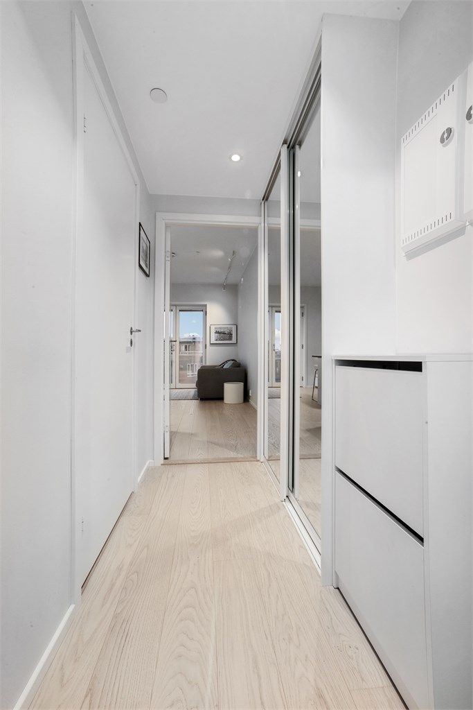 Lys entré med ny skyvedørsgarderobe med speilfronter.