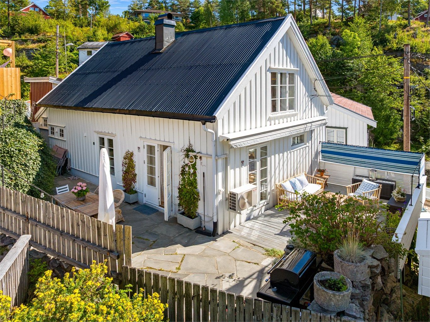 En oversikt over den private og solrike uteplassen med både treterrasse og skifer.