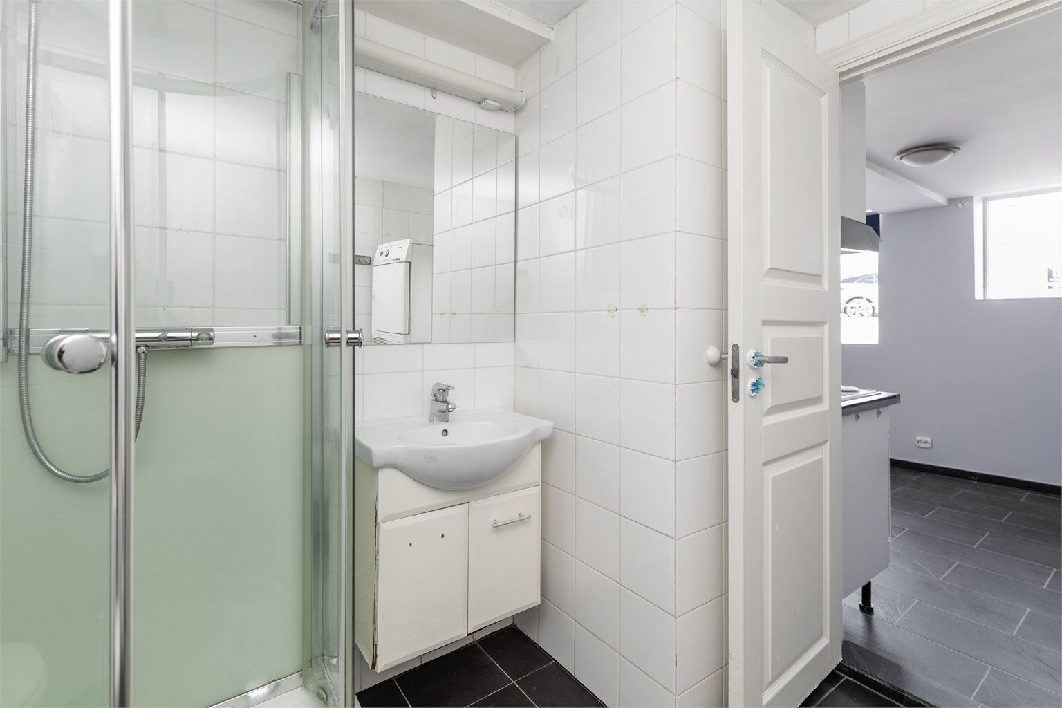 Badet i kjelleretasjen har dusjhjørne, servant og toalett.
