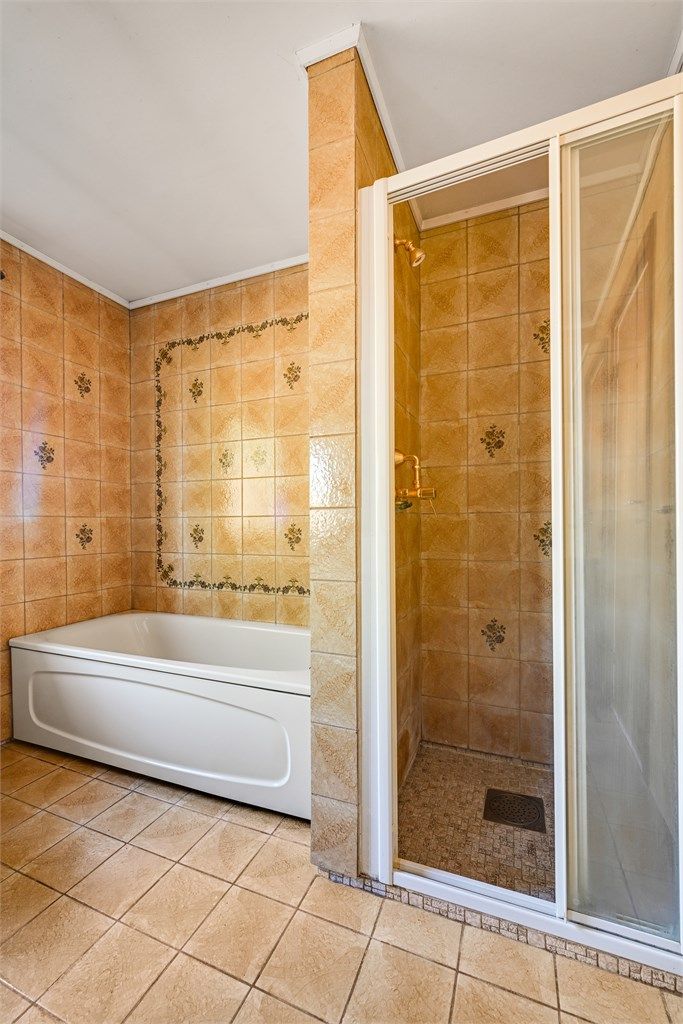 I tillegg til badekaret har badet en separat dusjnisje med skyvedører.