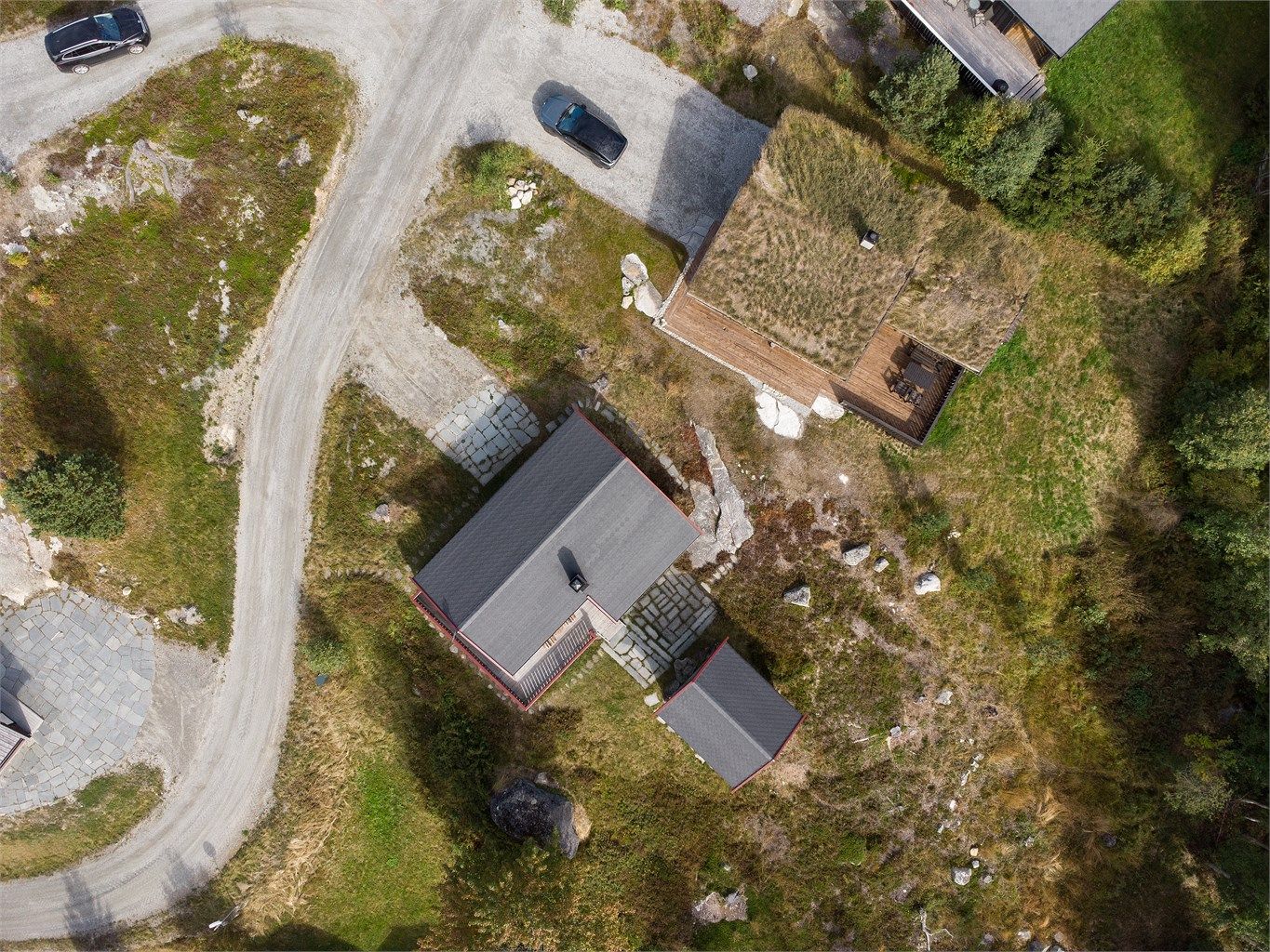 Tomten er opparbeidet med skiferlagte gangbaner og bevart naturtomt rundt bygningsmassen.