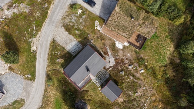 Tomten er opparbeidet med skiferlagte gangbaner og bevart naturtomt rundt bygningsmassen.
