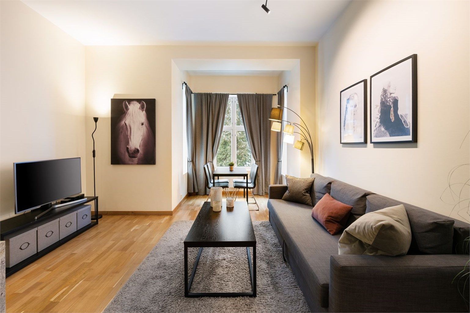 Hyggelig stue med plass til sofa med tilhørende salongbord, tv med tilhørende tv-møbler og spisebord.