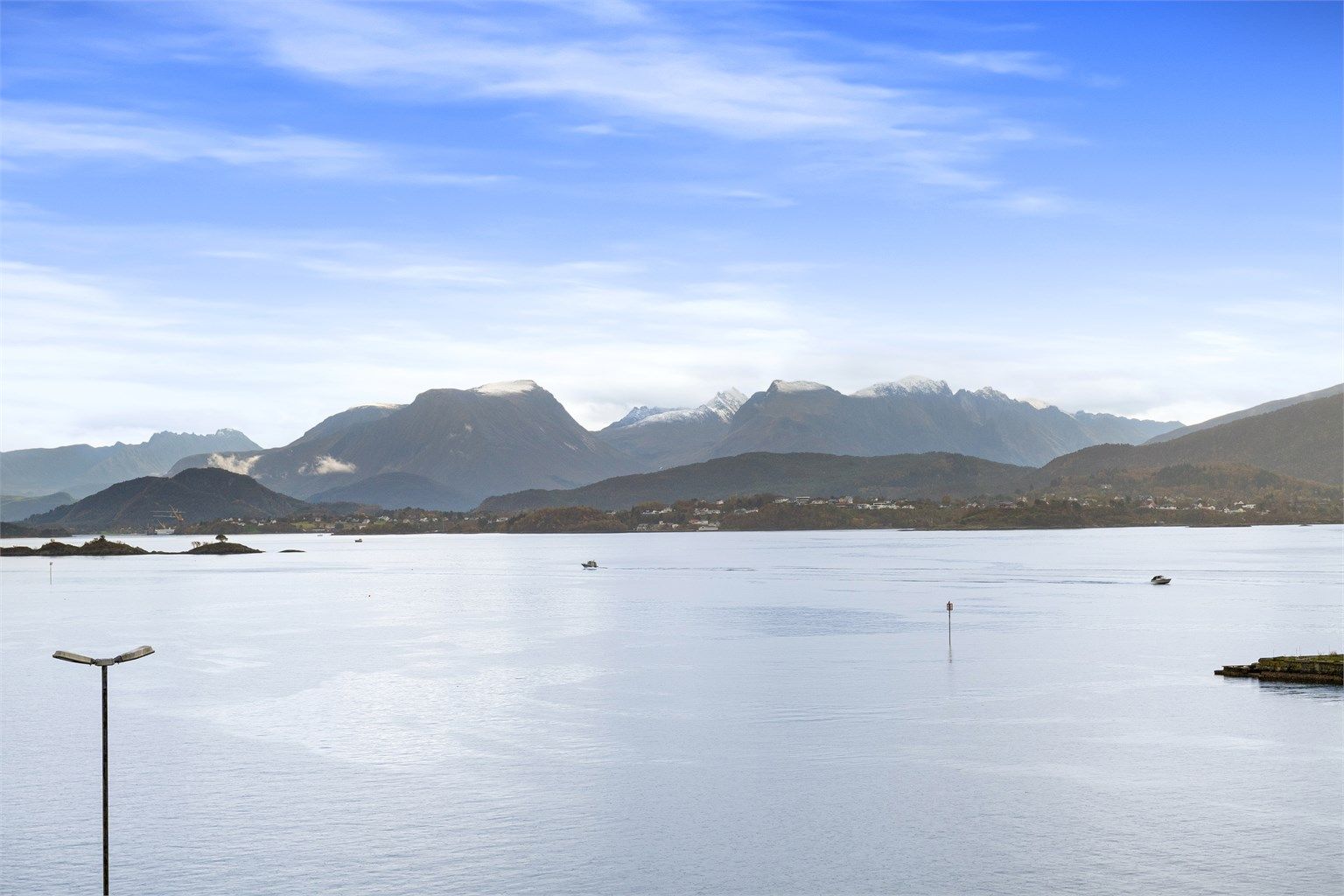 Åpent fjordlandskap med fjellene på Sunnmøre i bakgrunnen.