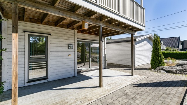 Uttrekkbar levegg begrenser innsyn til terrassen, som ellers oppleves som lun av det skjermende overbygget.