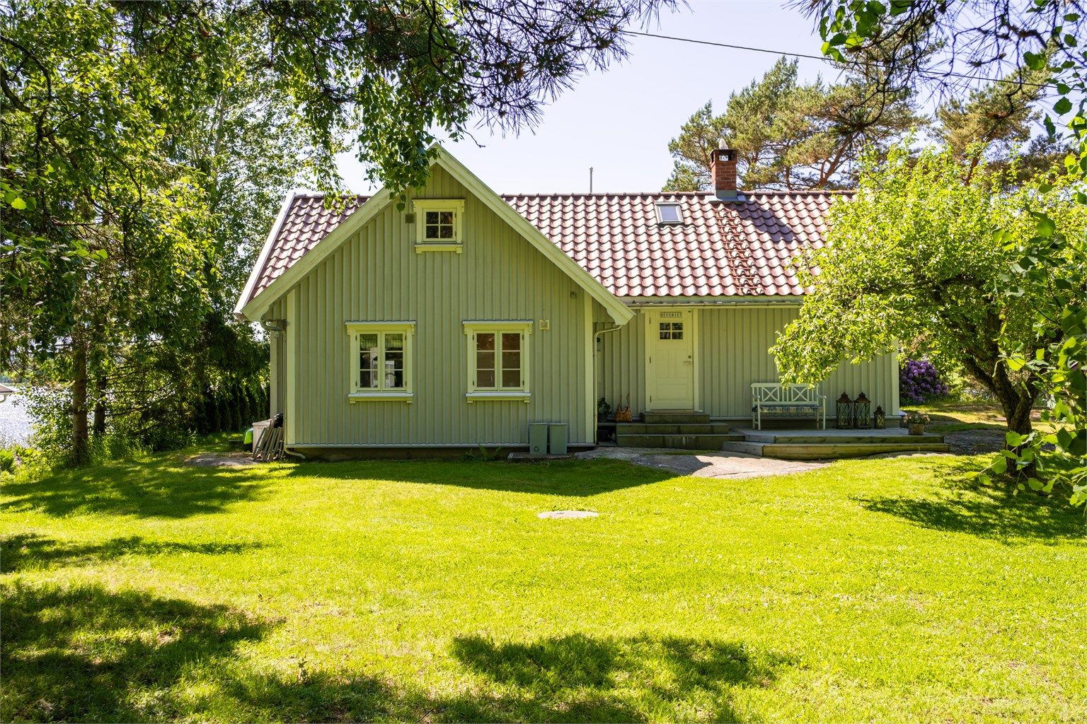 Plattingen foran inngangspartiet har sommerstid sol første del av dagen og er på vindfylte dager et lunere alternativ til den store og åpne på motsatt side.
