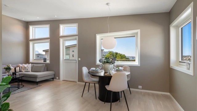 Den åpne løsningen gir god plass til både sofagruppe og spisebord. Den gode takhøyden gir en ekstra romslig følelse.
