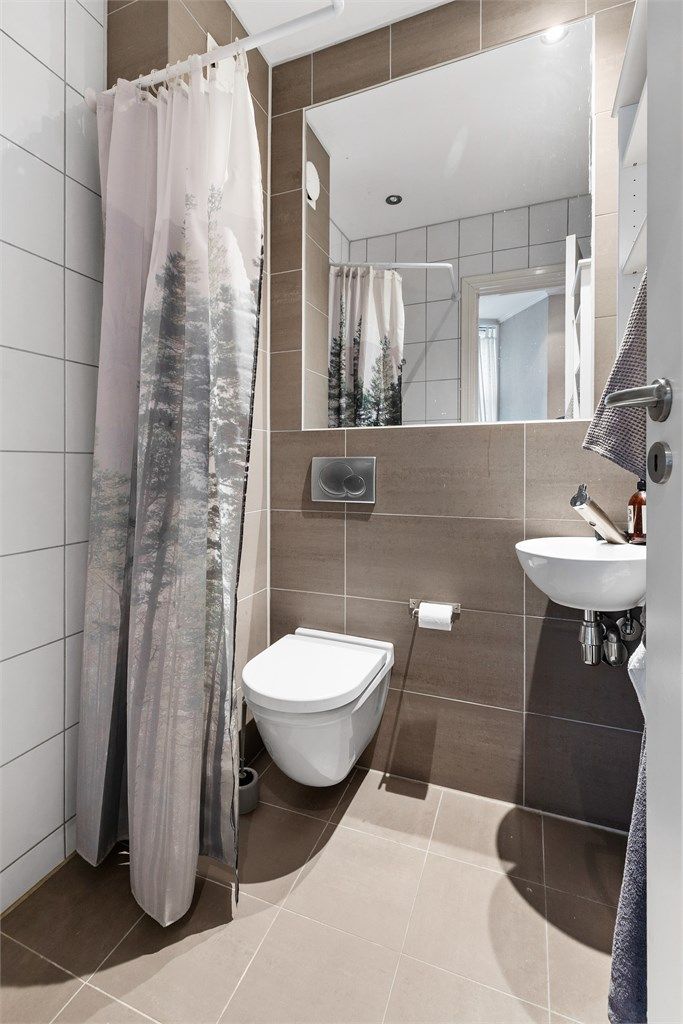 Badet i hybelen er fra 2009. Flislagt gulv med gulvvarme og flislagte vegger. Nedsenket himling med downlights. Vegghengt servant med ett-greps armatur. Speil med overlys. Dusjhjørne med forheng. Vegghengt dusjarmatur. Vegghengt toalett.