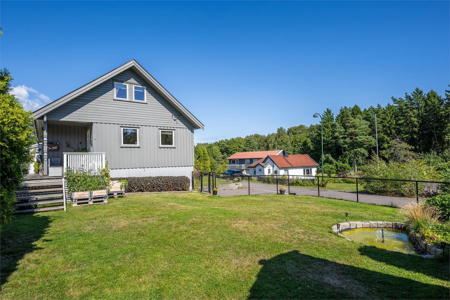Pent opparbeidet og inngjerdet hage som er trygg for barn og dyr.