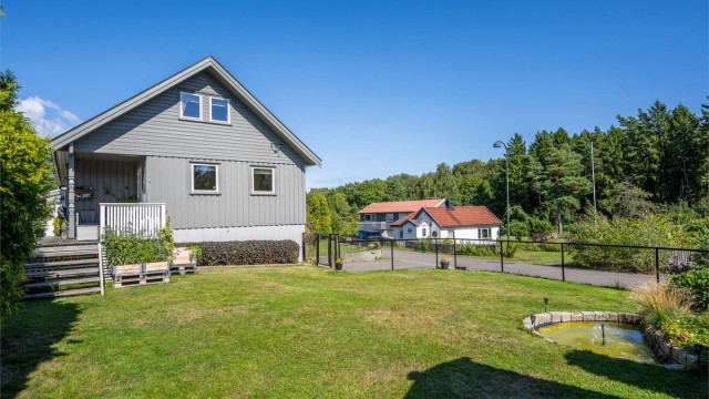 Pent opparbeidet og inngjerdet hage som er trygg for barn og dyr.