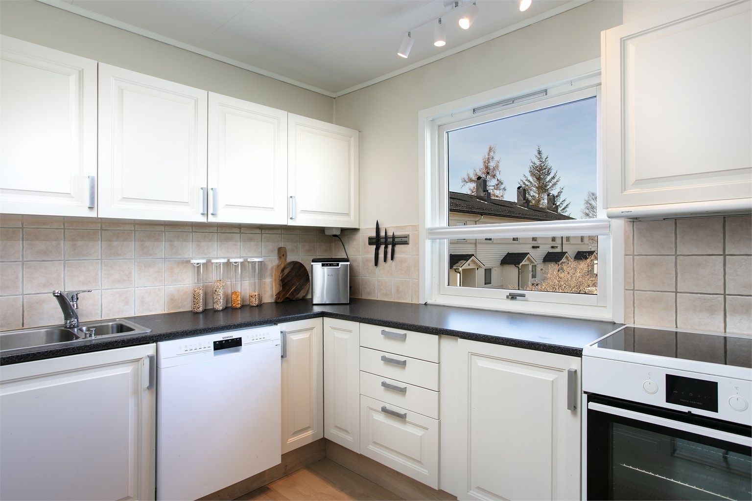 Kjøkkeninnredning med profilerte fronter og laminat benkeplate.