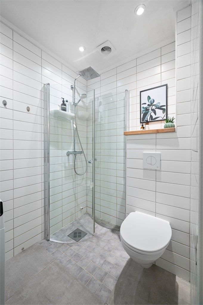 Videre har badet dusjhjørne med svingbare glassdører og innfelte downlights i taket.
