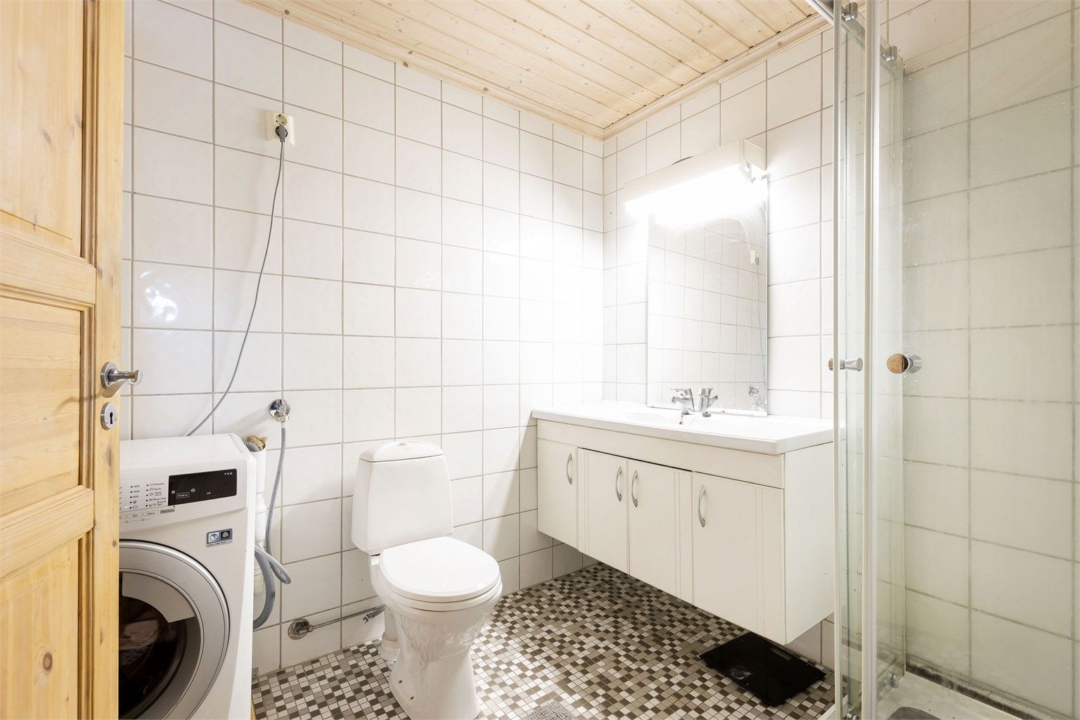 Flislagt bad med varmekabler. Dusjkabinett, servantinnredning, wc og opplegg til vaskemaskin