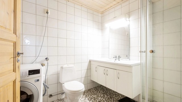 Flislagt bad med varmekabler. Dusjkabinett, servantinnredning, wc og opplegg til vaskemaskin