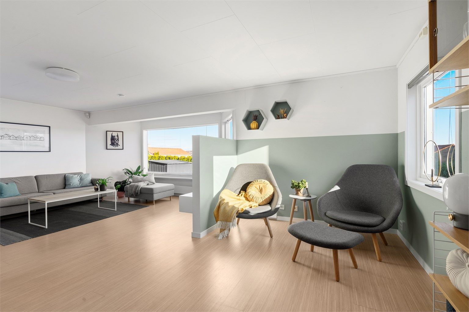 Stuen har ulike soner og veggen som er satt opp er en smart løsning for tv. 