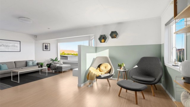 Stuen har ulike soner og veggen som er satt opp er en smart løsning for tv.