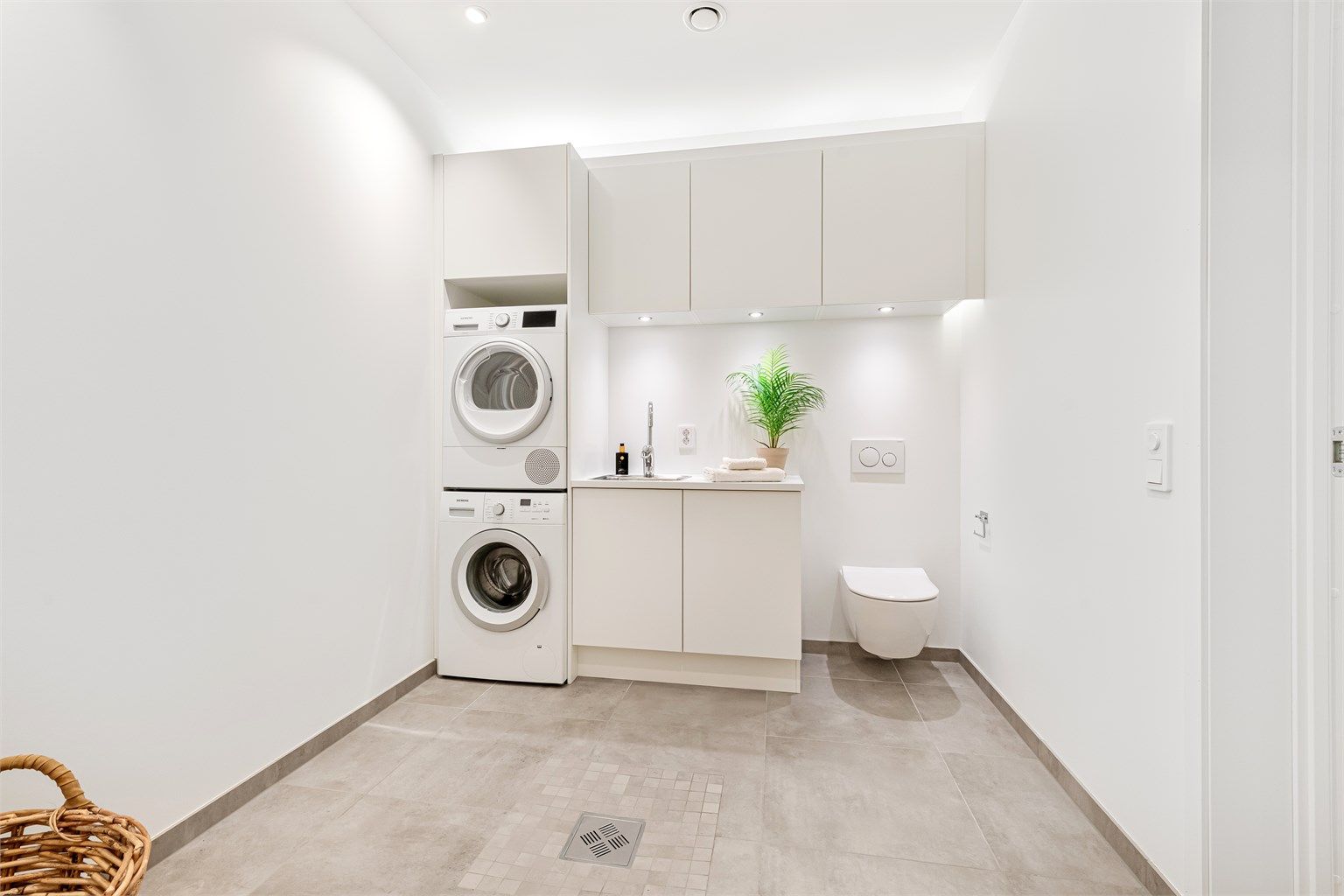 Vaskerom i underetasjen. Det er montert vegghengt toalett i rommet. Sikringsskap er også plassert her. 