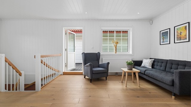 En terrassedør med glassfelt åpner opp til en skjermet takterrasse.